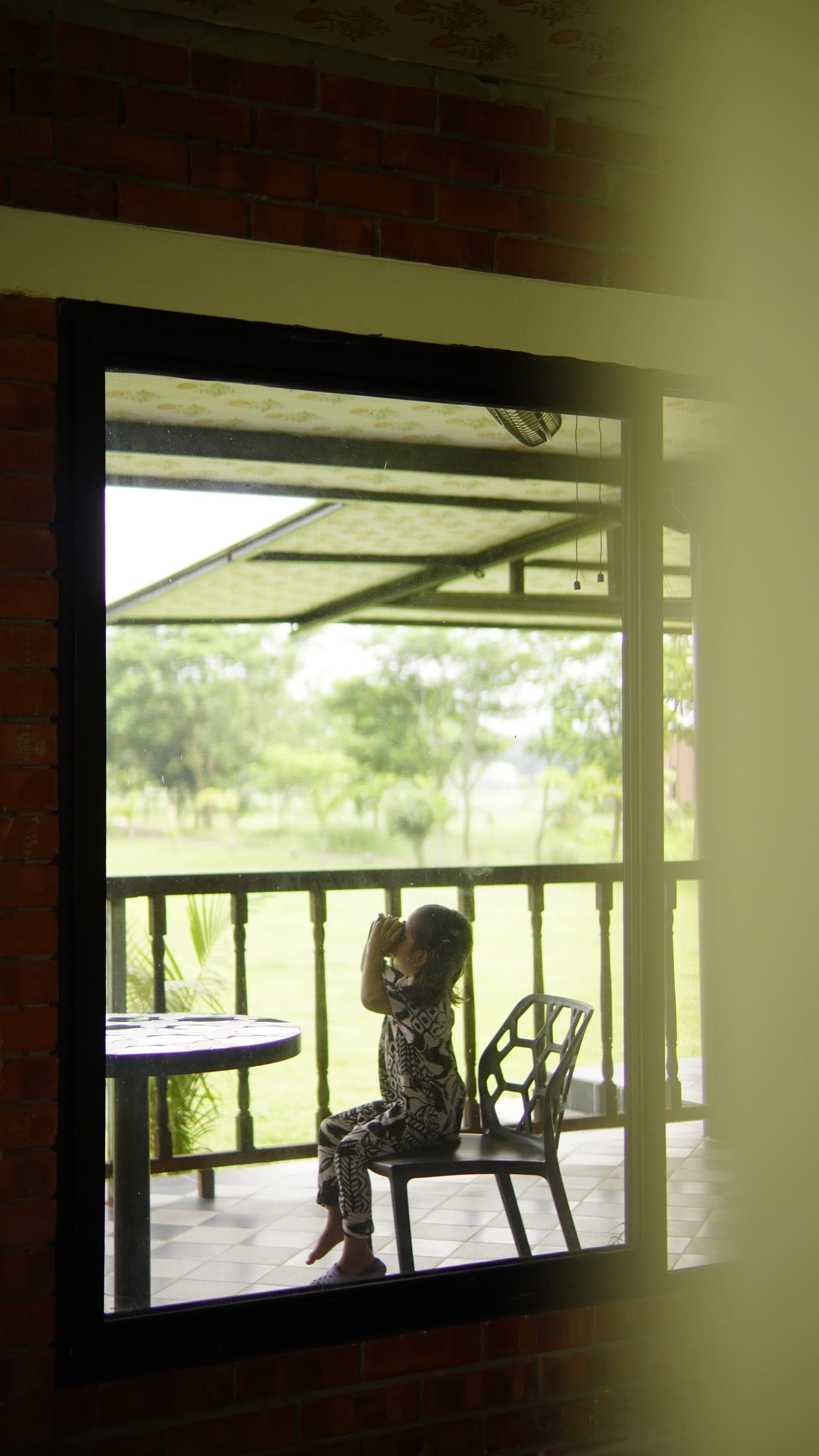 Child with binoculars on the balcony