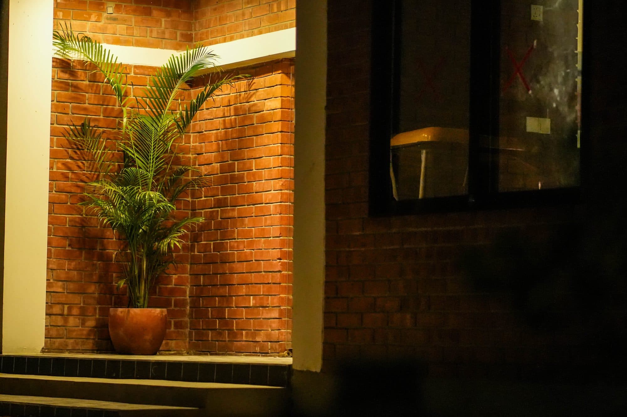 Lit balcony and brick room at night