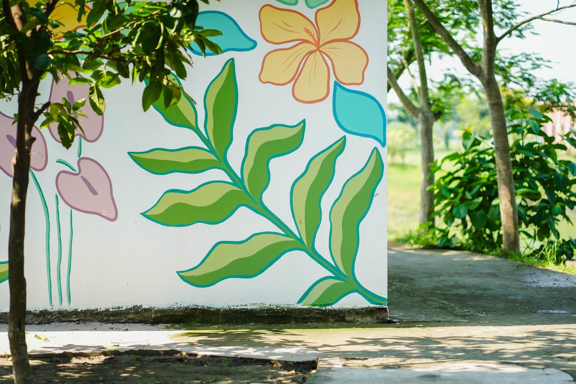 Hand-painted floral mural beside a garden path