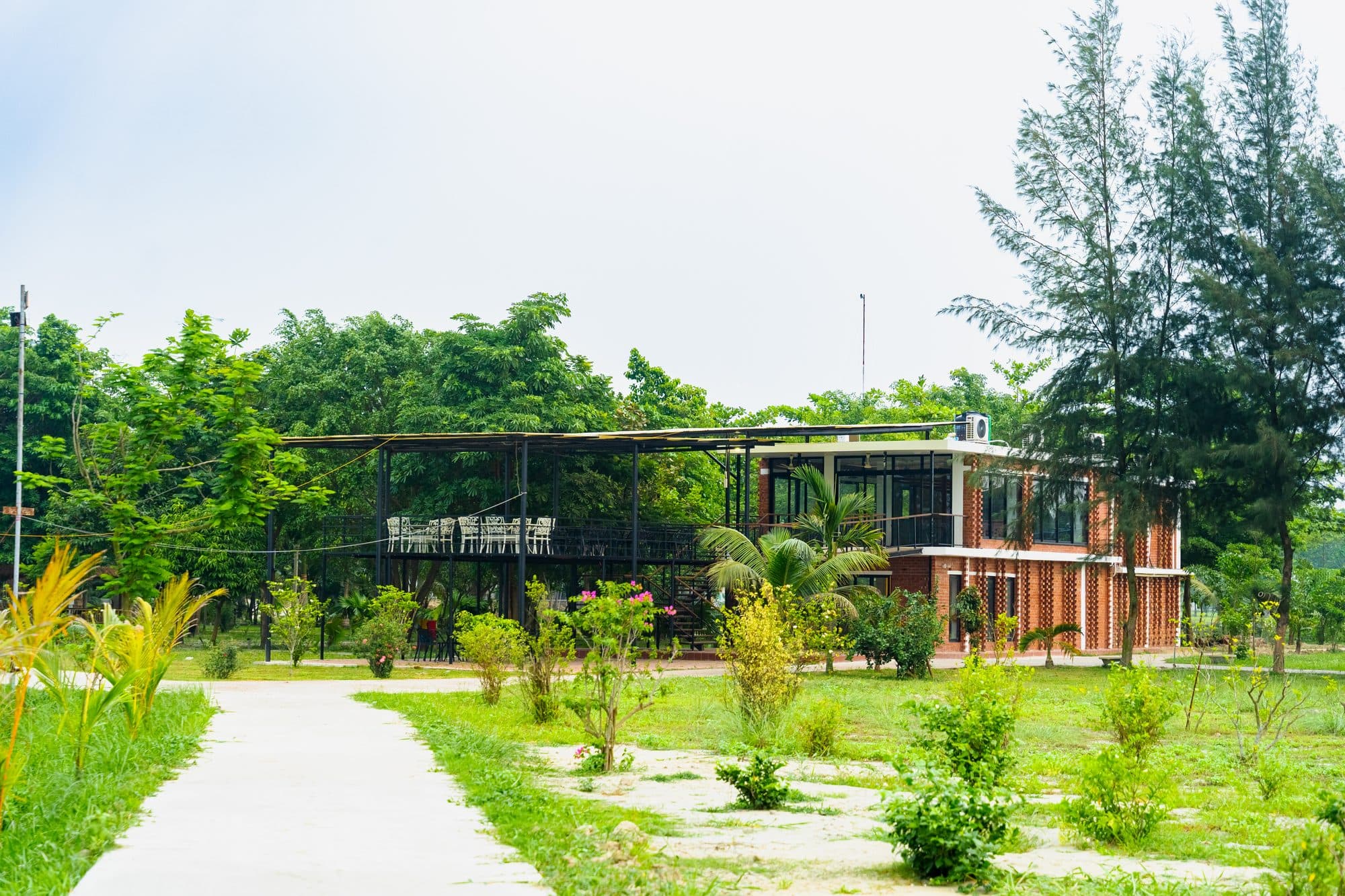 The Slow Garden retreat — main building, garden path, and covered deck among the trees.